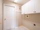 Laundry room with white cabinets, hooks, and tile flooring at 1639 Yellow Brick Rd, Astor, FL 32102
