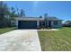 Charming single-story home with a dark grey garage door, fresh landscaping, and a well-manicured lawn at 182 Marion Oaks Mnr, Ocala, FL 34473