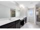 Bathroom with dual sinks, a large mirror, a vanity with storage, and a glass-enclosed shower at 1978 J Lawson Blvd, Orlando, FL 32824