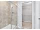Glass shower enclosure and walk-in closet featuring shelving in this well-appointed bathroom at 1978 J Lawson Blvd, Orlando, FL 32824