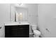 Well-lit bathroom featuring a dark vanity, white countertop, and matching toilet and sink at 1978 J Lawson Blvd, Orlando, FL 32824