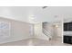 Bright living room with tiled floors, adjacent to a kitchen and a stairway to the second floor at 1978 J Lawson Blvd, Orlando, FL 32824