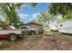 Spacious backyard of the house featuring various vehicles and ample parking, surrounded by lush greenery and mature trees at 205 W Division St, Deland, FL 32720