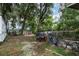 Backyard featuring large trees, a truck, shed, and an ATV behind a chain link fence at 205 W Division St, Deland, FL 32720