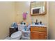 Compact bathroom features a toilet, sink with vanity, and a mirrored cabinet above the toilet at 205 W Division St, Deland, FL 32720