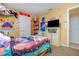 Bedroom featuring a bed, storage cabinet, a television and doorway into another room at 205 W Division St, Deland, FL 32720