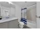 This bathroom features a tub with shower, a gray vanity, and modern lighting at 2210 Derwent Dr, Davenport, FL 33896