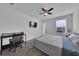 This bedroom has a ceiling fan, work station, and large window providing natural light at 2210 Derwent Dr, Davenport, FL 33896