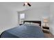 Comfortable bedroom features a bed with a dark headboard, side tables with lamps, and a fan at 2210 Derwent Dr, Davenport, FL 33896