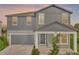 Charming two-story home with blue siding, a gray garage door, and a covered front porch at 2210 Derwent Dr, Davenport, FL 33896