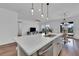 Bright, modern kitchen with stainless steel appliances and a spacious island flowing into an open-concept living space at 2210 Derwent Dr, Davenport, FL 33896