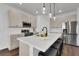 Modern kitchen featuring white cabinets, stainless steel appliances, and a large island with bar seating at 2210 Derwent Dr, Davenport, FL 33896