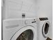 Modern laundry room featuring a white washer and dryer with wire shelving above at 2210 Derwent Dr, Davenport, FL 33896