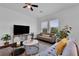 Bright living room with a large TV, comfortable seating, and ample natural light, creating a cozy and inviting space at 2210 Derwent Dr, Davenport, FL 33896