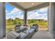 Relaxing covered patio with wicker furniture and serene backyard views, perfect for outdoor lounging and entertaining at 2210 Derwent Dr, Davenport, FL 33896