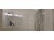 This walk-in shower is tiled in gray with a glass door and modern fixtures at 2210 Derwent Dr, Davenport, FL 33896