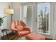 Cozy corner featuring a stylish armchair, ottoman, and natural light streaming through the window at 2305 Edgewater Dr # 1613, Orlando, FL 32804