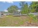 Backyard featuring a trampoline, swing set, white fence, mature trees, and garden, offering ample space for outdoor activities at 2312 Poinciana Rd, Winter Park, FL 32792