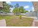 Backyard featuring a trampoline, swing set, white fence, and mature trees, offering ample space for outdoor activities at 2312 Poinciana Rd, Winter Park, FL 32792