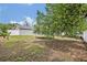 Backyard featuring a trampoline, white fence, mature trees, and garden, providing a private and serene outdoor space at 2312 Poinciana Rd, Winter Park, FL 32792