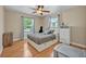 Neat bedroom with warm hardwood floors, two windows, a queen bed, and ample closet storage at 2312 Poinciana Rd, Winter Park, FL 32792
