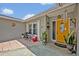 Inviting front porch with tiled floor, featuring a bright yellow door and decorative plants at 2312 Poinciana Rd, Winter Park, FL 32792