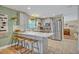 Open kitchen with stainless steel appliances, bar seating, and a view into an adjacent room at 2312 Poinciana Rd, Winter Park, FL 32792