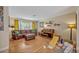 Comfortable living room with a piano, sectional couch and playroom area at 2312 Poinciana Rd, Winter Park, FL 32792