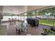Covered patio with a view of the lawn, seating area, barbecue grill, and play equipment at 2312 Poinciana Rd, Winter Park, FL 32792