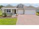 Charming single-story home with a two-car garage, brick-paved driveway, well-manicured lawn, and attractive landscaping at 2639 Ginseng Ivy St, Apopka, FL 32703