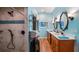 Bright bathroom with double vanity, beach-themed window art, and a tiled shower stall with a rainfall shower head at 287 Hilltop Dr, Longwood, FL 32750