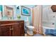 Colorful bathroom featuring blue walls, a wood vanity, and shower-tub combination, decorated with beach-themed accents at 287 Hilltop Dr, Longwood, FL 32750