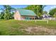 Charming tan home with vibrant blue door, green roof, and spacious front yard, offering a welcoming curb appeal at 287 Hilltop Dr, Longwood, FL 32750