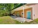 Back patio featuring neutral pavers, an aluminum roof, and a turquoise front door at 287 Hilltop Dr, Longwood, FL 32750