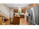 Bright kitchen with hardwood floors, stainless appliances, wood cabinets, kitchen island, and stairway to second level at 287 Hilltop Dr, Longwood, FL 32750