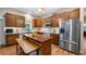 A kitchen featuring warm wood cabinets, stainless steel appliances, and a center island with seating, all bathed in natural light at 287 Hilltop Dr, Longwood, FL 32750