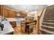 Cozy kitchen with wood cabinets, stainless appliances, and a central island, leading to a dining area with built-in bookshelves at 287 Hilltop Dr, Longwood, FL 32750