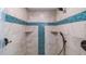 The upgraded shower is tiled with marble and teal tiles, a shower head, and convenient shelves for storage at 287 Hilltop Dr, Longwood, FL 32750