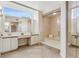 Bright bathroom featuring double sinks, a vanity, a large mirror and walk in shower at 2926 Claremont Ct # Ge, Orlando, FL 32822