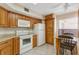 This kitchen features oak cabinets, white appliances, tile floors and a table with chairs at 2926 Claremont Ct # Ge, Orlando, FL 32822