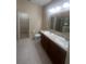 A well-lit bathroom features double sinks, granite countertops, a large mirror, and tile flooring at 2983 Boating Blvd, Kissimmee, FL 34746