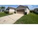 A residential home featuring an attached two-car garage and a well-maintained driveway at 2983 Boating Blvd, Kissimmee, FL 34746