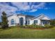Single-story home featuring stone accents, arched entryway, landscaped front yard, and visible 'Sales Center' sign at 3126 Wolf Lake Ave, Apopka, FL 32712