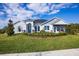 Charming single-story home boasts a manicured front lawn, stone accents, arched entryway, and a sales center at 3126 Wolf Lake Ave, Apopka, FL 32712