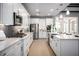 Bright kitchen with stainless steel appliances, white cabinets, and quartz countertops at 3126 Wolf Lake Ave, Apopka, FL 32712