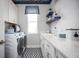 Bright laundry room featuring patterned tile floors, white cabinetry, and modern appliances at 3126 Wolf Lake Ave, Apopka, FL 32712