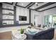 Modern living room with custom shelving, sleek furniture, and a seamless flow to the outdoor space at 3126 Wolf Lake Ave, Apopka, FL 32712