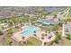 A gorgeous aerial view of community amenities featuring a resort-style pool, clubhouse, and beautifully landscaped grounds at 3280 Canna Lily Pl, Clermont, FL 34711