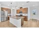 Kitchen with stainless steel appliances, granite counters, and wooden cabinets, with a view to the living room at 3280 Canna Lily Pl, Clermont, FL 34711