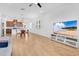 Bright open concept living room featuring tile floors, mounted TV, and open kitchen with dining area at 3280 Canna Lily Pl, Clermont, FL 34711